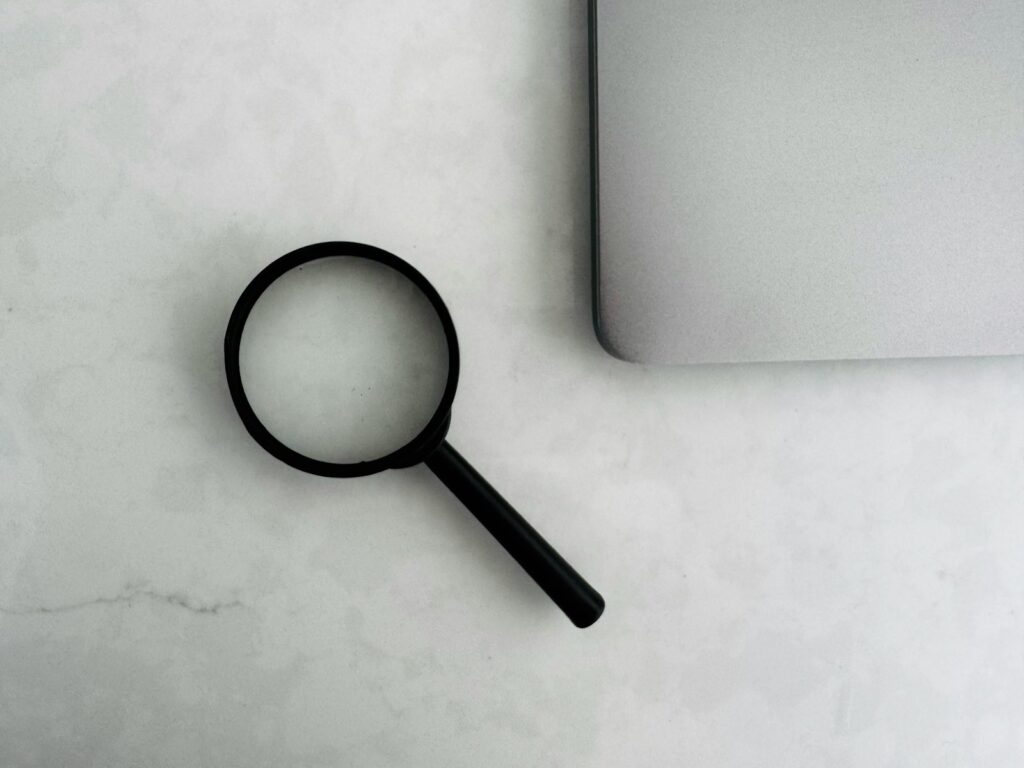 SEO vs. SEA: Lupe neben einem Laptop als Symbol für die Suche