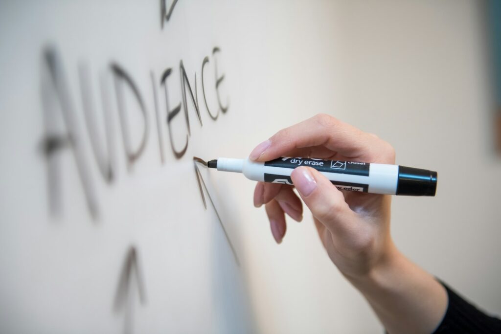 Digital-Marketing-Agentur plant Strategie: Hand schreibt mit Marker auf ein Whiteboard