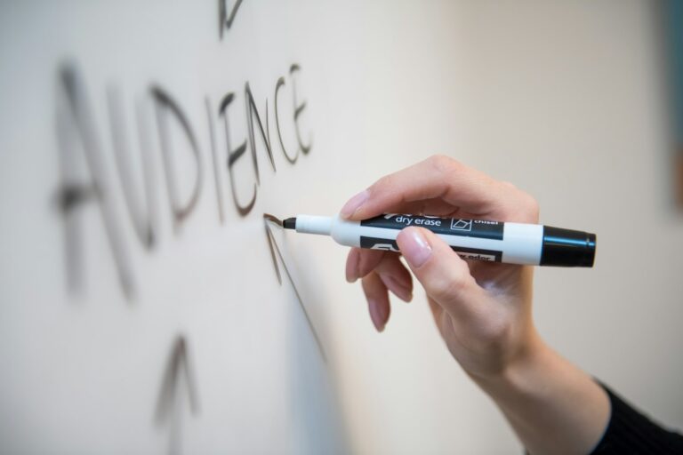 Digital-Marketing-Agentur plant Strategie: Hand schreibt mit Marker auf ein Whiteboard
