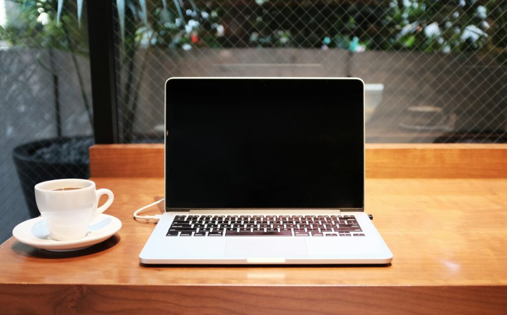 Ergebnisse der Digital-Marketing-Agentur prüfen: Laptop mit Kaffeetasse am Arbeitsplatz