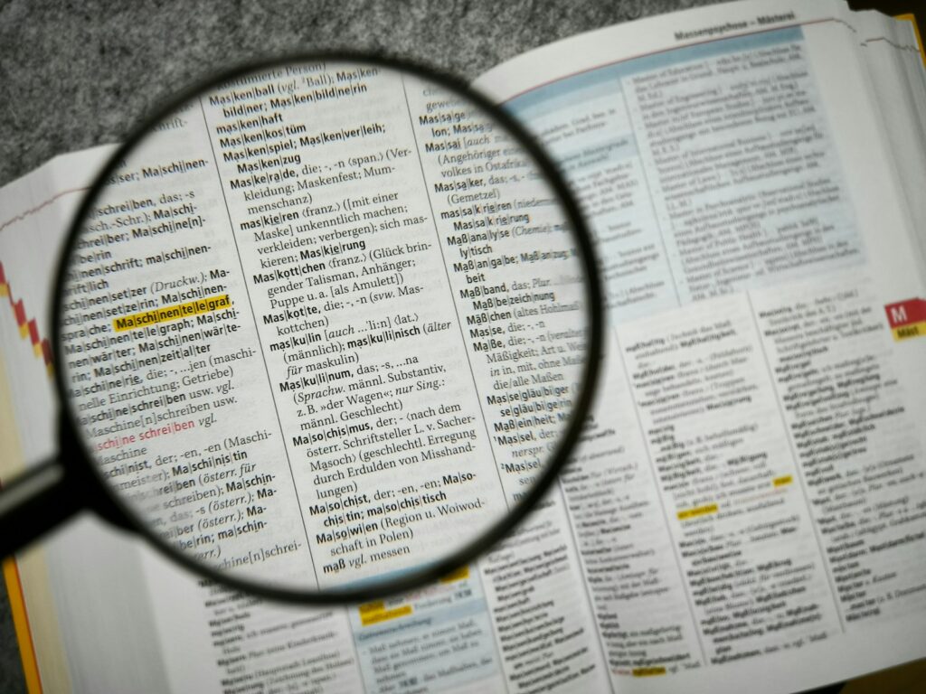 Keywords in der KI-Suche: Lupe über einer Wörterbuchseite als Symbol für Begriffsrecherche