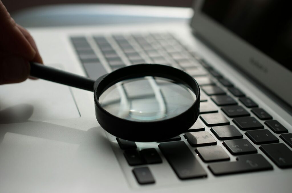 Keywords in der KI-Suche messen: Lupe neben einem Laptop