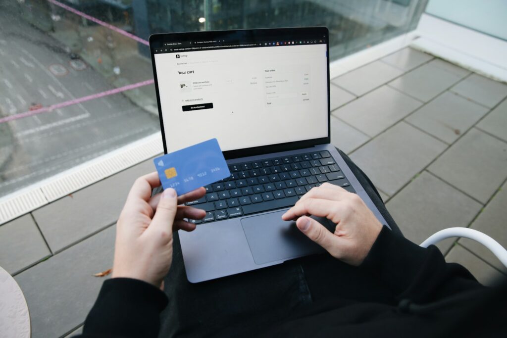 KI-Agenten und AI SEO: Person kauft mit Kreditkarte am Laptop ein