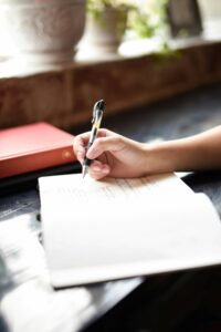KI-Content-Optimierung: Person schreibt mit Stift auf Papier