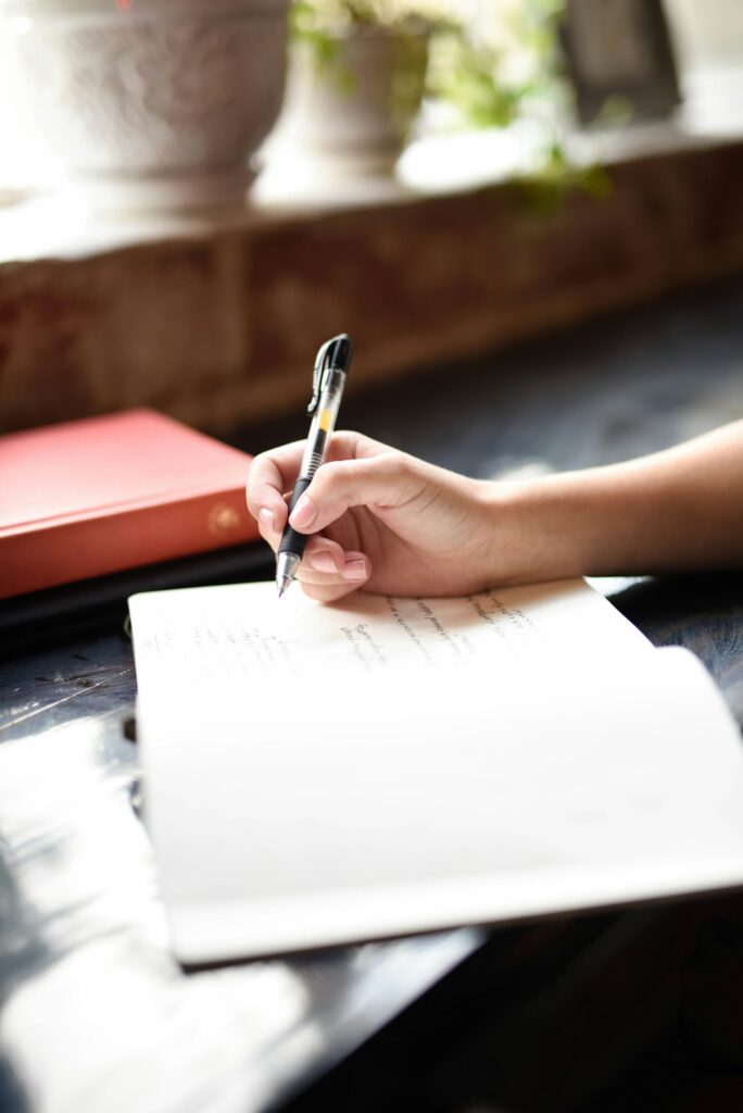 KI-Content-Optimierung: Person schreibt mit Stift auf Papier