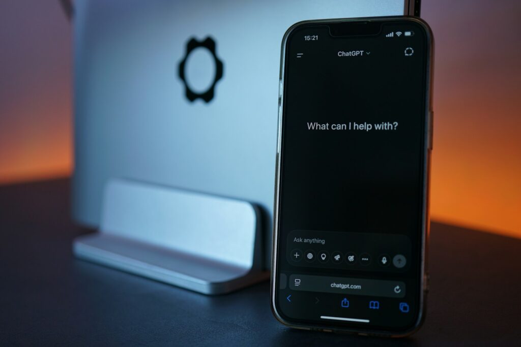 KI im Vertrieb: Smartphone mit ChatGPT neben einem Laptop