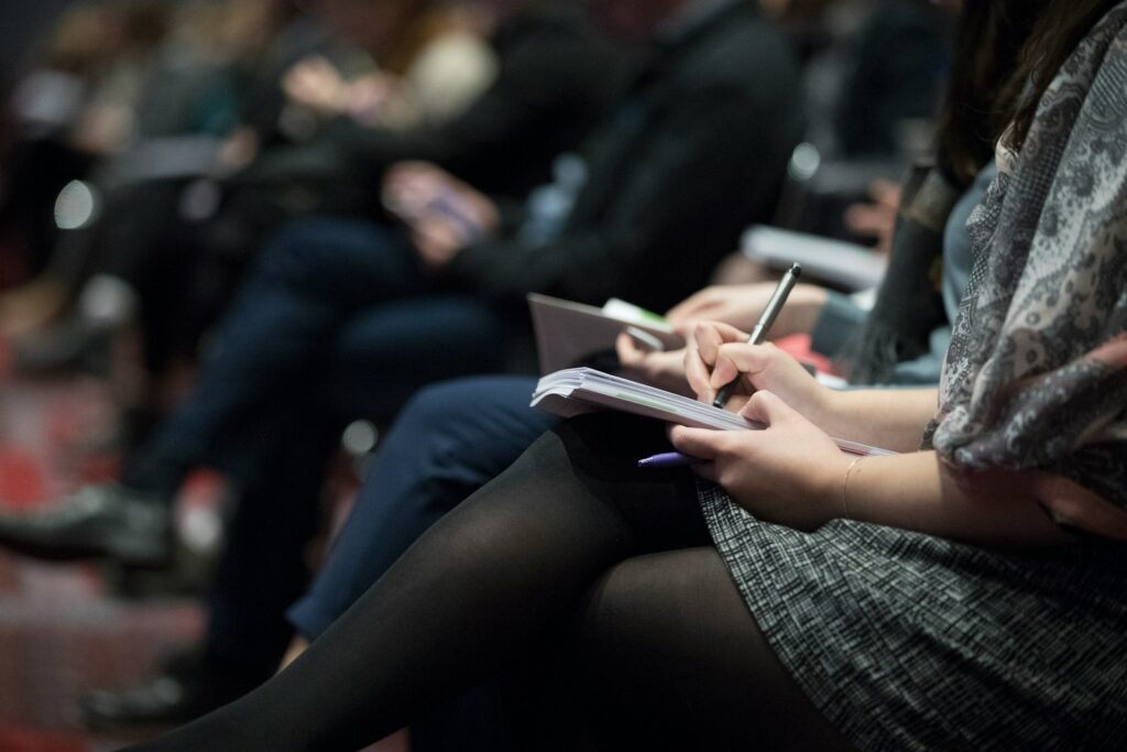 PR-Agentur und Journalisten: Menschen machen Notizen bei einer Veranstaltung