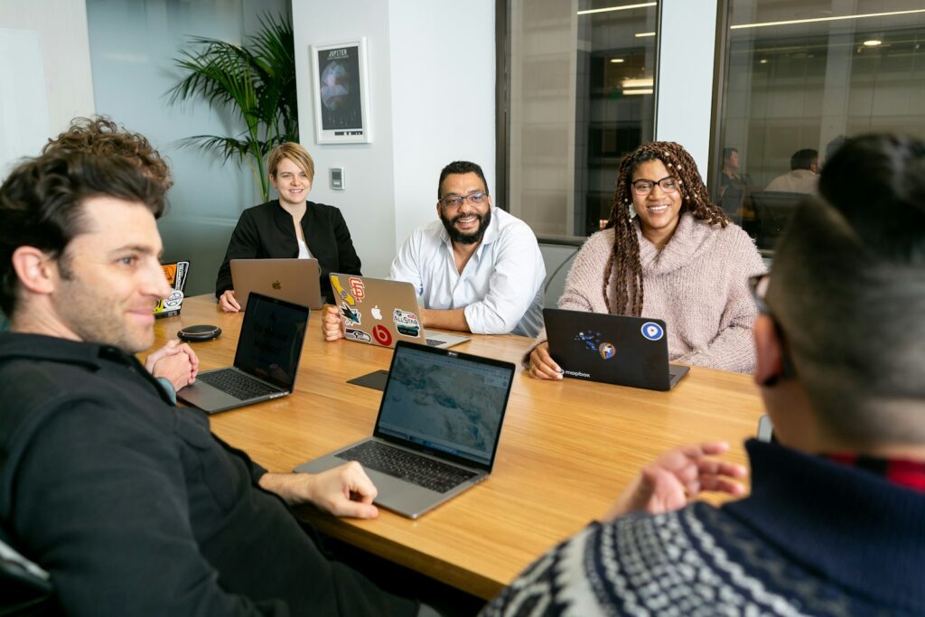 SEO Dienstleistungen besprechen: Team mit Laptops im Meeting
