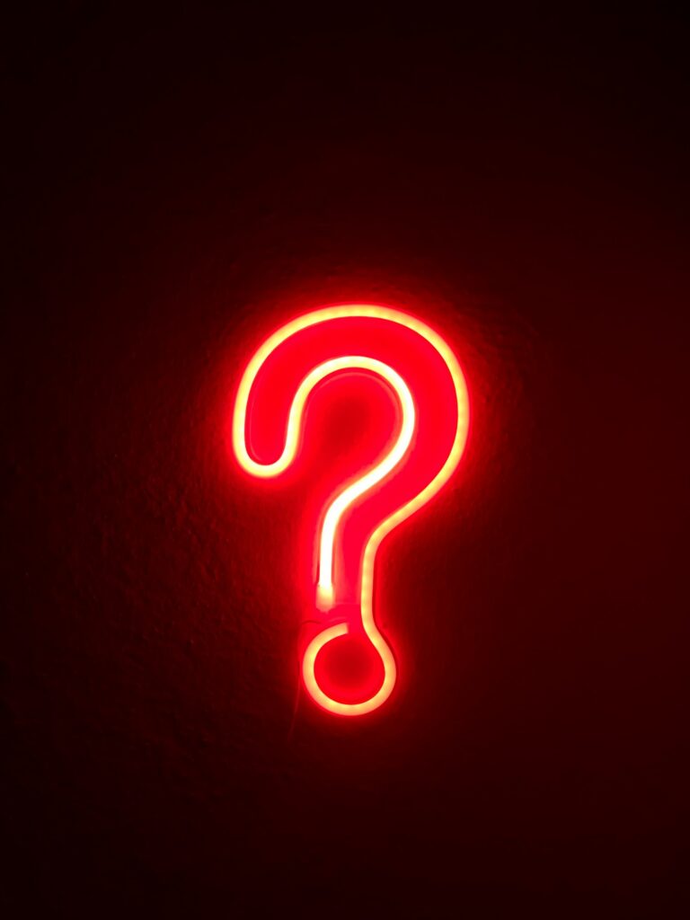SEO-Mythen hinterfragen: rotes Neon-Fragezeichen an einer Wand