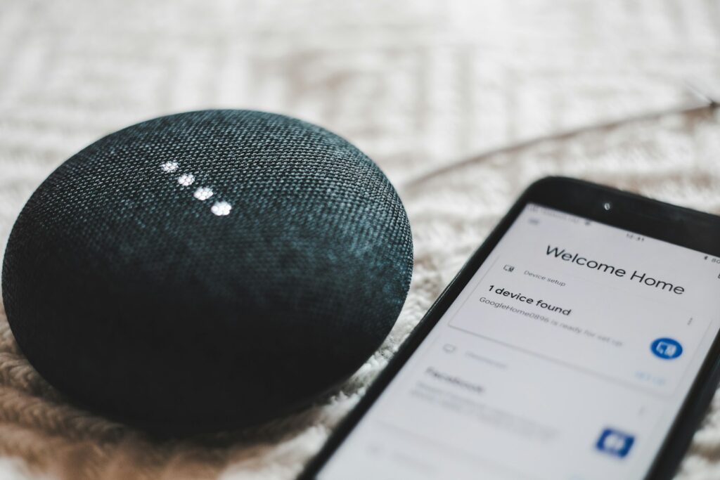 Smart Speaker neben Smartphone als Beispiel für Answer Engine Optimization bei Sprachassistenten