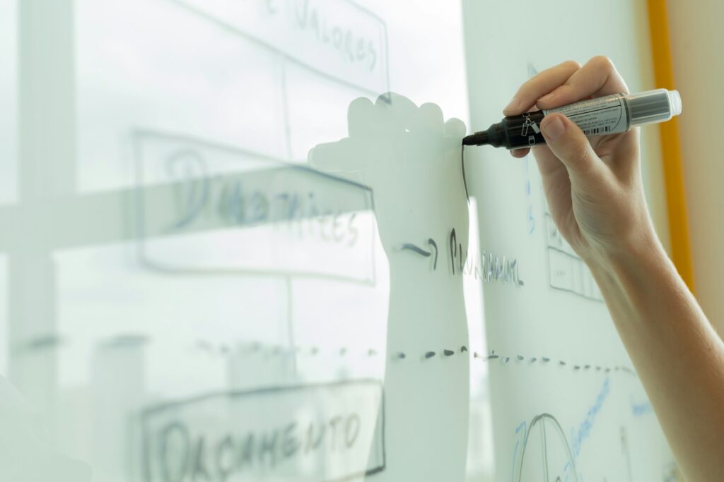 Gemini SEO: Hand zeichnet ein Strategie-Diagramm an ein Whiteboard