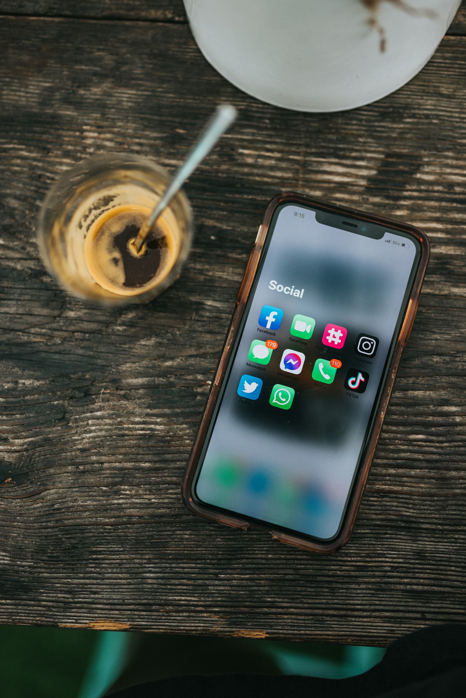 Social Media Marketing Kosten: Smartphone mit Social-Media-Apps neben einem Glas Kaffee