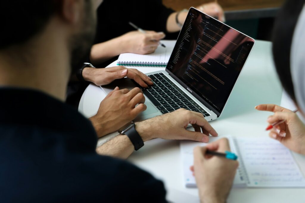 Team bespricht am Laptop eine Strategie für die KI-Suche