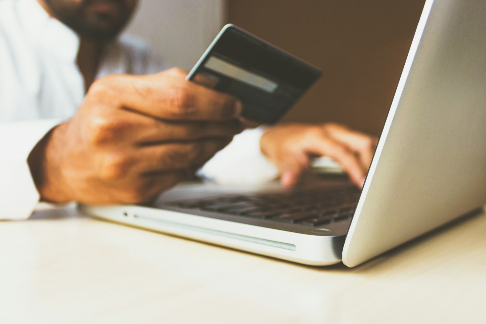 Channable: Person kauft am Laptop mit Kreditkarte online ein