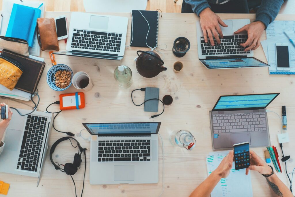 Google Ads Budget: Team bespricht Kampagnen an einem Tisch mit Laptops