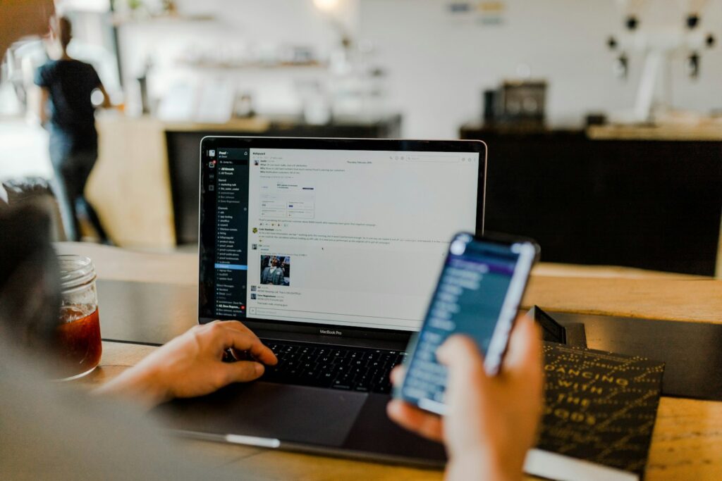 Reddit-Marketing im Arbeitsalltag: Person nutzt Smartphone und Laptop
