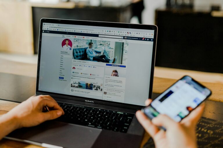 Person nutzt Laptop und Smartphone
