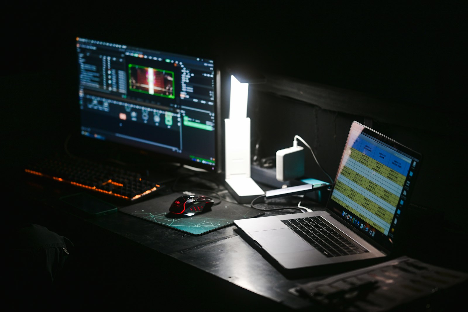 Copilot vs. ChatGPT: Laptop und Monitor an einem dunklen Arbeitsplatz