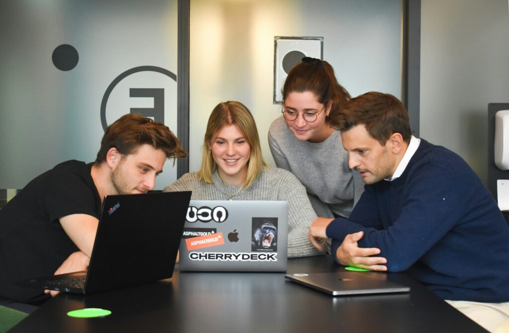 Team im Büro entscheidet über Copilot vs. ChatGPT am Laptop