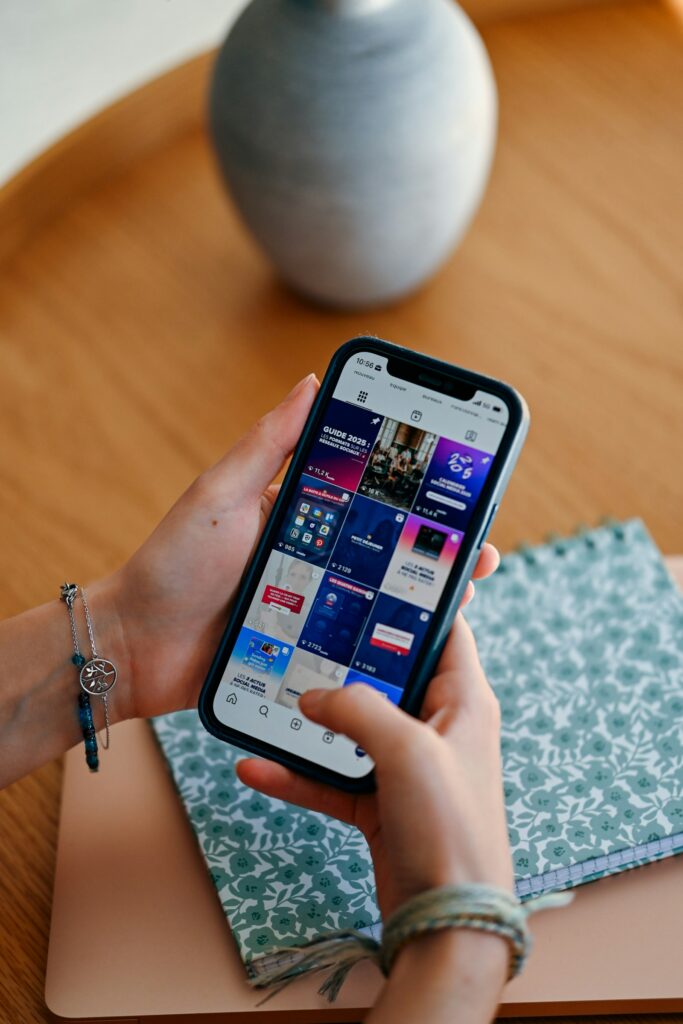 Meta Ads im Feed: Hände halten ein Smartphone mit Social-Media-Feed