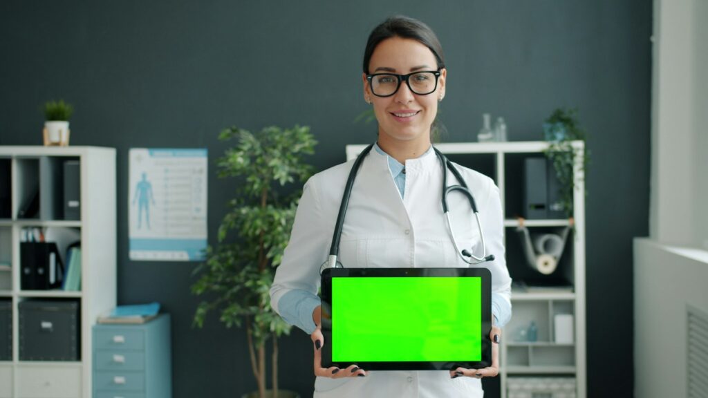 SEO für Ärzte: Arzt hält ein Tablet mit digitaler Praxisanwendung